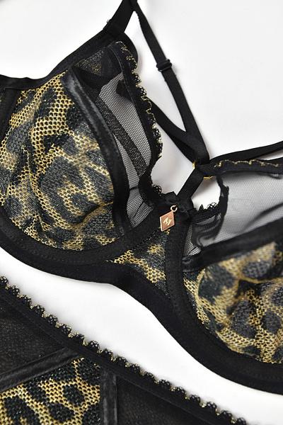 Biustonosz Safari Soft 19179 to wyjątkowy model biustonosza miękkiego, który łączy w sobie elegancję i komfort noszenia. Miseczki wykonane są z czarnej siateczki, co nadaje biustonoszowi subtelny, ale zarazem wyrafinowany wygląd. Dół biustonosza dodatkowo pokryty jest siatką w cętki ze złotą nitką, co dodaje całości niepowtarzalnego charakteru i luksusowego wykończenia.
W dekolcie znajduje się ozdobny straps, który można dowolnie odpiąć, co pozwala na personalizację wyglądu biustonosza i dostosowanie go do różnych stylizacji. Obwód biustonosza wykonany z czarnej siatki zapewnia komfort noszenia, a brak bocznych fiszbin dodatkowo zwiększa wygodę i sprawia, że biustonosz idealnie dopasowuje się do sylwetki.
Biustonosz jest wykonany z wysokiej jakości materiałów - 85% poliamidu, 10% elastanu i 5% poliestru, co gwarantuje trwałość, elastyczność i miękkość, jednocześnie zapewniając doskonałe dopasowanie do ciała. To idealne połączenie stylu, wygody i luksusu, idealne dla kobiet ceniących sobie zarówno elegancję, jak i komfort codziennego użytkowania.

 