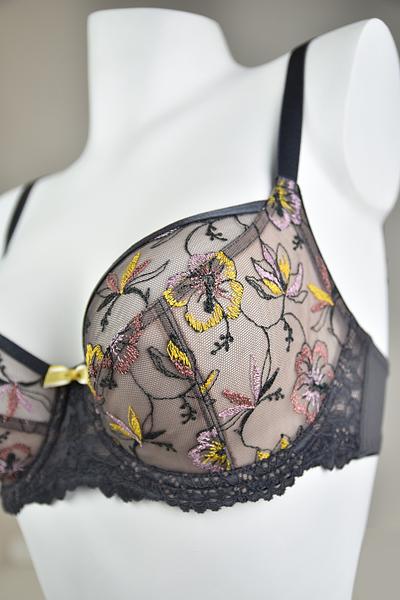 Biustonosz miękki  z fiszbinami.
Miseczki z beżowej siatki, na którą naszyty jest wzorzysty plen-motyw kwiatowy na grafitowym podkładzie.
Boczki z mikrofibry-wzmocnione fiszbiną, grafitowe ramiączka, bawet z koronki, środek zdobi zółta kokardka.
Pewna i sprawdzona konstrukcja z modelu Deziro dedykowana dla średnichi dużych biustów.
Skład surowcowy: 85%Poliamid, 10% Elastan, 5%Poliester.
 