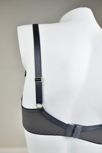 Biustonosz miękki  z fiszbinami.
Miseczki z beżowej siatki, na którą naszyty jest wzorzysty plen-motyw kwiatowy na grafitowym podkładzie.
Boczki z mikrofibry-wzmocnione fiszbiną, grafitowe ramiączka, bawet z koronki, środek zdobi zółta kokardka.
Pewna i sprawdzona konstrukcja z modelu Deziro dedykowana dla średnichi dużych biustów.
Skład surowcowy: 85%Poliamid, 10% Elastan, 5%Poliester.
 