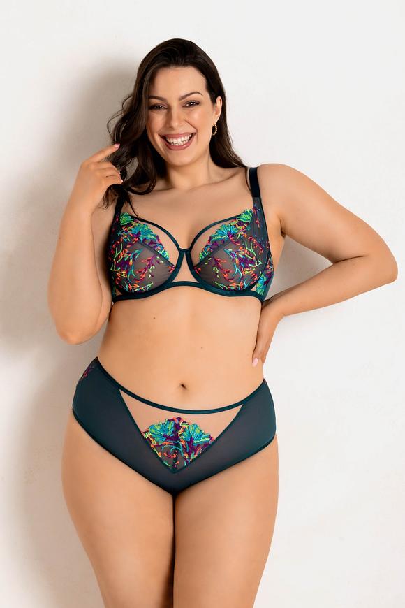 Biustonosz Illusion Soft 19233 Mediolano to kwintesencja zmysłowej lekkości i wyrazistego stylu. Wykonany z transparentnej siateczki, zdobionej intensywnym, kolorowym haftem, przyciąga wzrok niczym biżuteria dla ciała. Konstrukcja typu soft, inspirowana modelem Deziro, zapewnia naturalny kształt biustu, jednocześnie pięknie go zbierając i podtrzymując. Brak bocznych fiszbin zwiększa komfort noszenia, a elastyczny obwód miękko dopasowuje się do sylwetki. Szmaragdowe lamówki i detale dodają całości elegancji i świeżości. Regulowane ramiączka oraz wygodne zapięcie na haftkę gwarantują idealne dopasowanie. To model dla kobiet ceniących oryginalność, komfort i wyrazistość.
Konstrukcja MS1 DEZIRO
Skład surowcowy: 85%Poliamid, 10%Elastan, 5%Poliester.